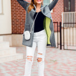 Fashion image of stylish blond woman in grey coat walking on the street. Full lenght.